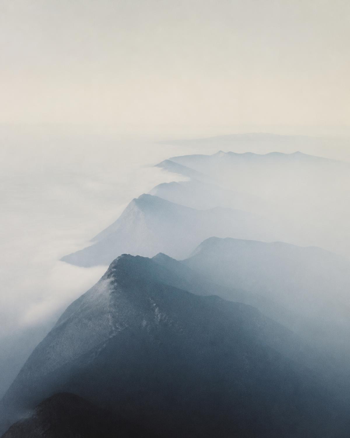 A distant mountain ridge dissolving into clear pale air